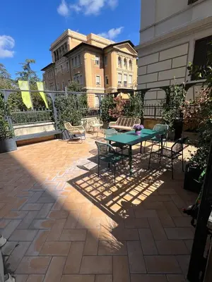a patio with a table and chairs and a building at Savoia design apartment with terrace - Rome center in Rome