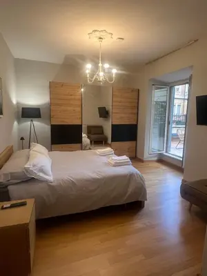 a bedroom with a large bed and a chandelier at Savoia design apartment with terrace - Rome center in Rome