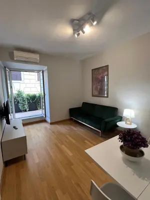 a living room with a green couch and a table at Savoia design apartment with terrace - Rome center in Rome