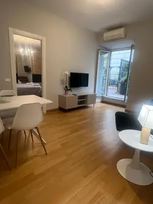 a living room with a table and a tv at Savoia design apartment with terrace - Rome center in Rome