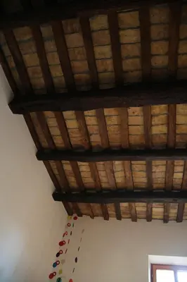 a room with a wooden ceiling with a bunch ofools at Casa del Drago in Trastevere in Rome