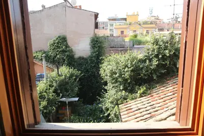 a window with a view of trees and buildings at Casa del Drago in Trastevere in Rome