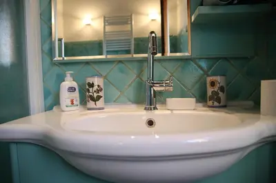 a white sink in a bathroom with a mirror at Casa del Drago in Trastevere in Rome