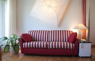 a red couch in a living room with a lamp at Pràti Home in Rome