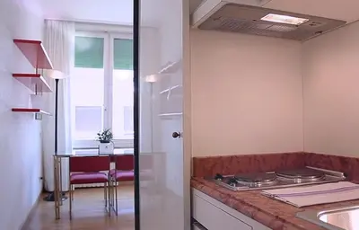 a kitchen with a stove and a table with a window at Pràti Home in Rome