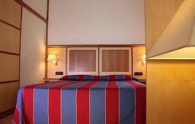 a hotel room with a bed with a red and blue stripes at Pràti Home in Rome