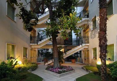 a courtyard of a building with a tree and flowers at Pràti Home in Rome
