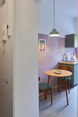 a small kitchen with a wooden table and a table and chair at Bivio - Casa Verde in Rome