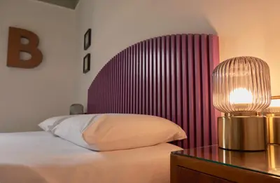 a bedroom with a bed and a table with a lamp at Bivio - Casa Verde in Rome