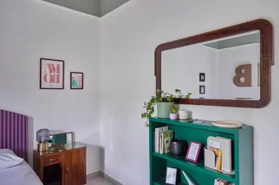 a bedroom with a green book shelf and a mirror at Bivio - Casa Verde in Rome