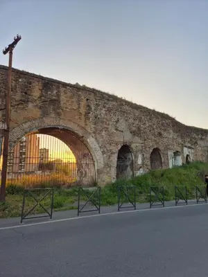 an old brick wall with a row of gates at Bivio - Casa Verde in Rome