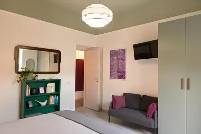 a bedroom with a bed and a couch and a mirror at Bivio - Casa Verde in Rome
