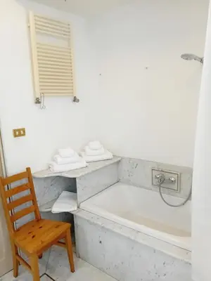 a bathroom with a tub and a wooden chair at Bed & Breakfast da Monica in Rome