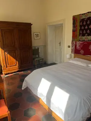 a bedroom with a large bed and a wooden cabinet at Bed & Breakfast da Monica in Rome