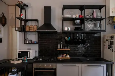 a kitchen with a stove and a black brick wall at Artist Vatican House in Rome