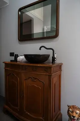 a bathroom sink with a mirror on top of a dresser at Artist Vatican House in Rome