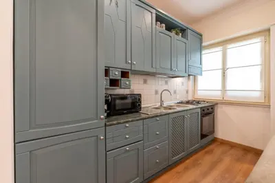 a kitchen with blue cabinets and a sink at Vatican Oasis - Free Parking, 4-6 pax, 2 bedrooms in Rome