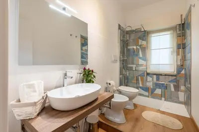 a bathroom with a large white sink and a toilet at Vatican Oasis - Free Parking, 4-6 pax, 2 bedrooms in Rome