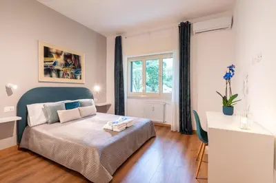 a bedroom with a bed and a table and a window at Vatican Oasis - Free Parking, 4-6 pax, 2 bedrooms in Rome