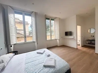 a bedroom with a large bed and two windows at Montezebio Boutique Rooms in Rome