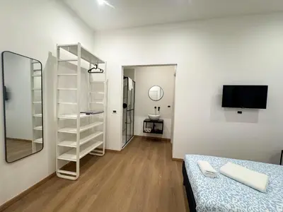 a white room with a bed and a mirror at Montezebio Boutique Rooms in Rome