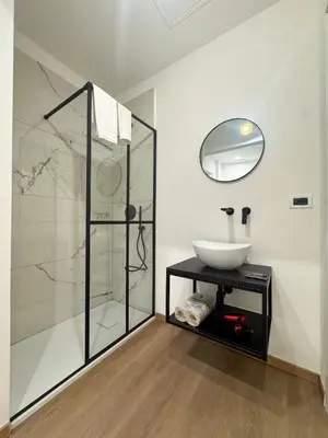 a bathroom with a sink and a glass shower at Montezebio Boutique Rooms in Rome
