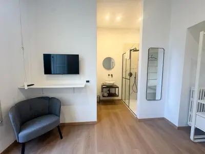 a living room with a chair and a tv on a wall at Montezebio Boutique Rooms in Rome