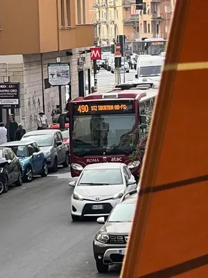a bus driving down a busy city street with cars at TopVaticanApartment in Rome