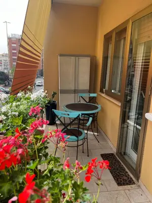 a balcony with a table and chairs and flowers at TopVaticanApartment in Rome