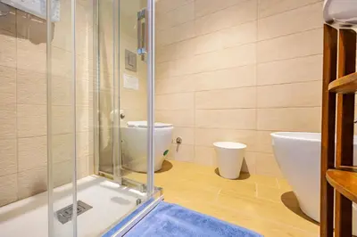 a bathroom with a toilet and a glass shower at Luminosa camera con bagno privato interno - vicina alla metro in Rome