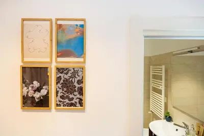 a bathroom with four pictures on a wall with a sink at Luminosa camera con bagno privato interno - vicina alla metro in Rome