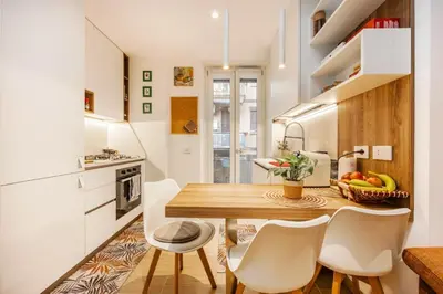 a kitchen and dining room with a wooden table and chairs at Luminosa camera con bagno privato interno - vicina alla metro in Rome