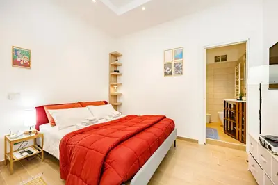 a bedroom with a bed with a red blanket at Luminosa camera con bagno privato interno - vicina alla metro in Rome