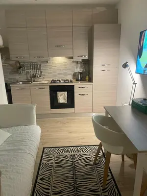 a kitchen with a table and a desk and a kitchen with a stove at Bilocale Socrates in Rome