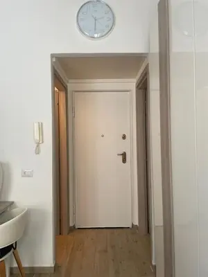 a clock on the wall above a white door at Bilocale Socrates in Rome
