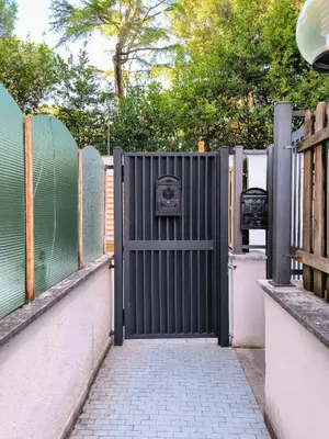 an open gate with a fence and a sidewalk at A casa di Piero in Rome