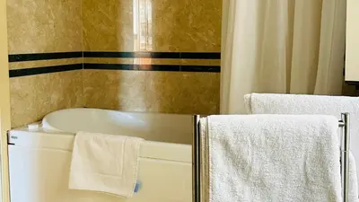 a bathroom with a bath tub and towels at Terrazza Urania - Penthouse terrace with 360 view of Rome in Rome