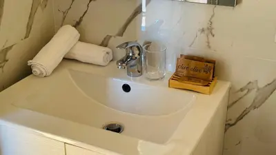 a white sink in a bathroom with towels on it at Terrazza Urania - Penthouse terrace with 360 view of Rome in Rome