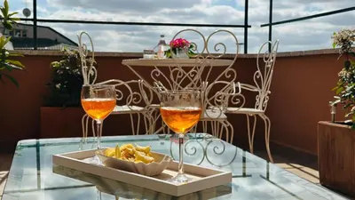two glasses of wine and a bowl of chips on a table at Terrazza Urania - Penthouse terrace with 360 view of Rome in Rome