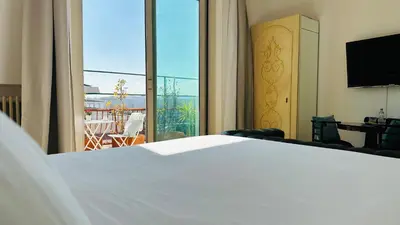 a bedroom with a white bed and a large window at Terrazza Urania - Penthouse terrace with 360 view of Rome in Rome