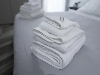 a stack of white towels sitting on a bathroom counter at F House Trastevere in Rome