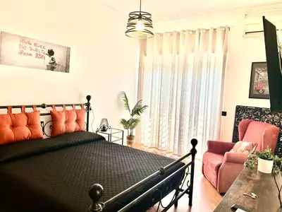 a bedroom with a black bed and a pink chair at Marisa lovely house in Rome