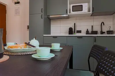 a kitchen with a wooden table with plates and cups at Vatican Vista Apartment in Rome