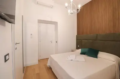 a bedroom with a large bed with a green headboard at Re Di Rhome Guest House in Rome
