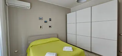 a bedroom with a yellow bed and white cabinets at Cento House Casa Vacanze Roma in Rome