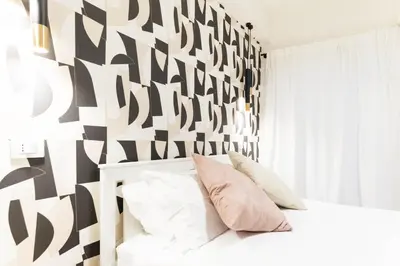 a white bedroom with a black and white wall at GENESI Suites in Rome