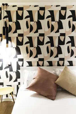 a bedroom with a black and white patterned wall at GENESI Suites in Rome