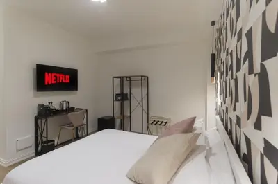 a bedroom with a bed and a clock on the wall at GENESI Suites in Rome