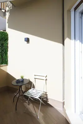 a table and a chair in a room with a window at GENESI Suites in Rome