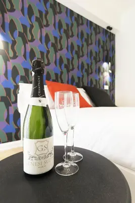 a bottle of wine and two glasses on a table at GENESI Suites in Rome